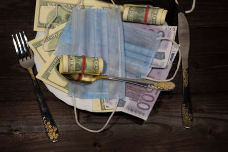 A plate with dollars and euros is standing on darkの写真素材