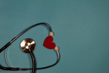 A stethoscope and a heart lie on a blue background.の写真素材