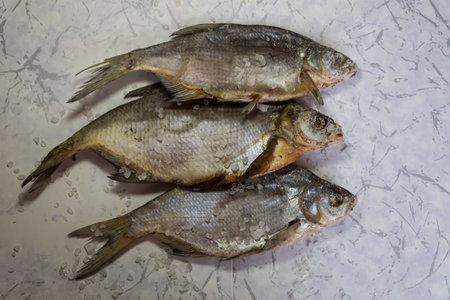 On the table are three dried river fish and salt.
