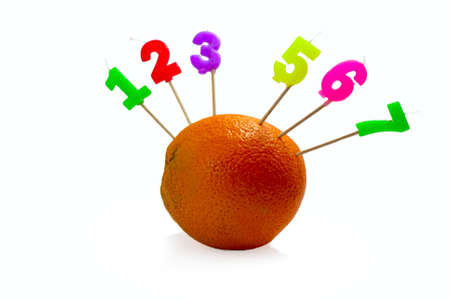 Orange with candles in the shape of numbers の写真素材