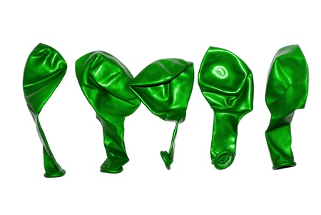 Five non-inflated balloons green color, isolated on white.の写真素材