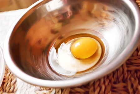  Metal bowl with the egg on the kitchen table.の写真素材