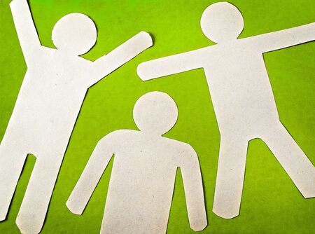 Three paper man on a green backgroundの写真素材