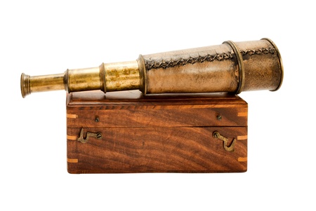 Antique spyglass and a wooden chest, isolated on white.の写真素材