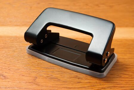 Hole puncher on a wooden background.の写真素材