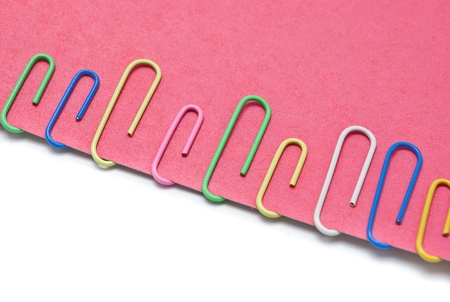 Some clips on pink paper against the white background.