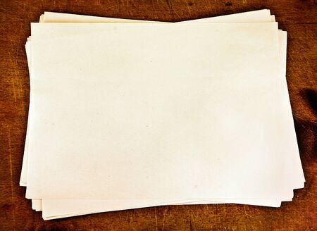 Stack of paper on a wooden background.