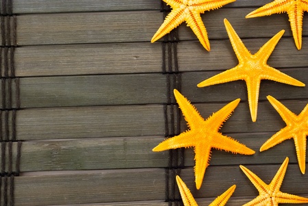 Few orange seastars on a wooden mat.の写真素材