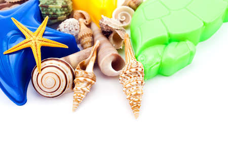 Closeup of summer still life- colorful toys and seashells on white.