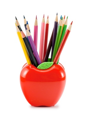Colorful pencils in red apple- shaped stand, isolated on white.の写真素材