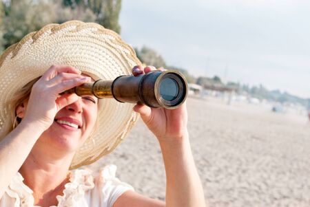 Portrait of mature women watching in a spyglass.の写真素材
