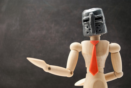 Classic wooden dummy in medieval helmet and red tie.の写真素材