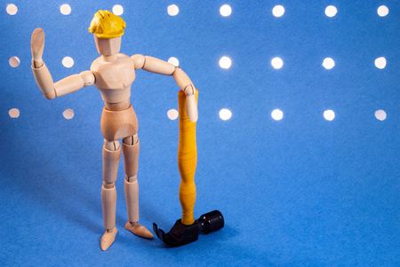 Classic wooden dummy as a builder on a blue background.の写真素材