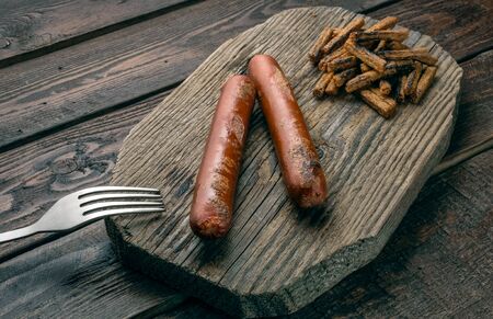 Grilled sausages on wood plate with fork, parsley and toasted breadの写真素材