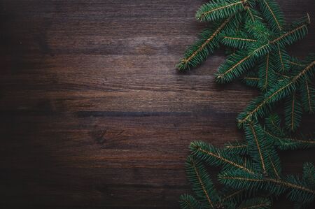 Dark wooden background with fir branches. Top view. Christmas decorationの写真素材