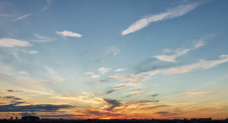 Colorful sunset sky with clouds over evenings cityの写真素材