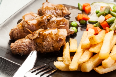 Beef rolls and vegetables on plate の写真素材