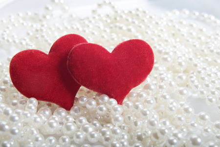 Red hearts on pearls background  Focus on heartsの写真素材