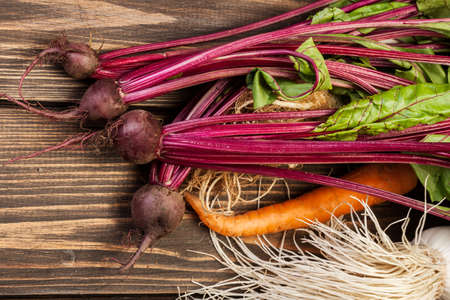 Beetroots, carrots and leek on a wooden tableの写真素材