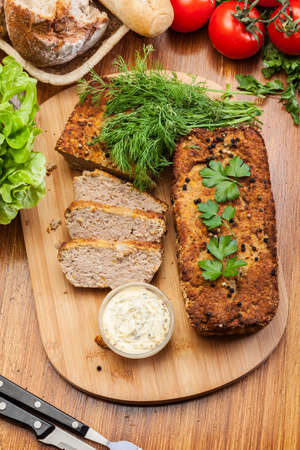 Traditional delicious meat pate with vegetables on wooden boardの写真素材