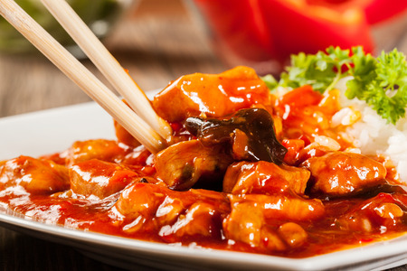 Sweet and sour chicken with rice on a plateの写真素材