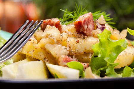 Scalloped potatoes with sausage and bacon on a plateの写真素材