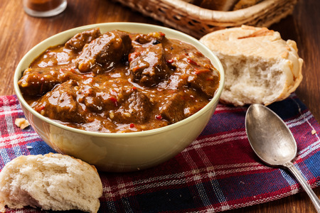 Beef stew served with crusty bread in a bowlの写真素材