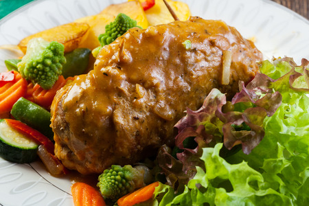 Pork rolls with prepared potatoes and vegetables on plate