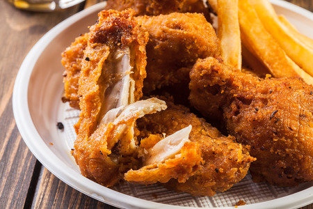 Crisp crunchy golden chicken wings with chipsの写真素材