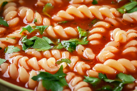 Tomato soup noodles in the bowl on a wooden tableの写真素材