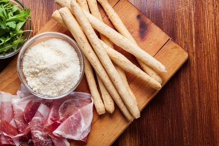 Traditional italian grissini with ham prosciutto, mozzarella and arugulaの写真素材