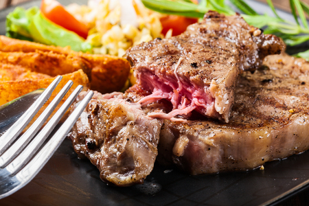Succulent portion of beef steak served with roast potatoesの写真素材