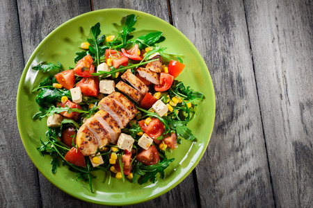 Fresh salad with chicken breast, arugula and tomato on a plateの写真素材