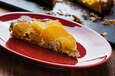 Slice of tart with cottage cheese and sliced orangeの写真素材