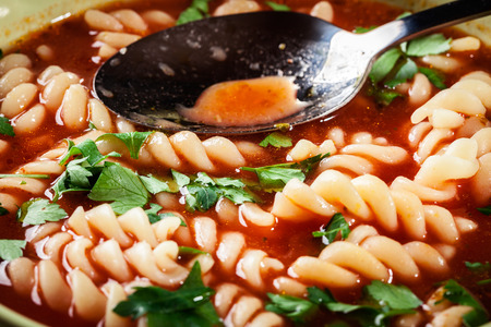 Tomato soup noodles in the bowl on a wooden tableの写真素材