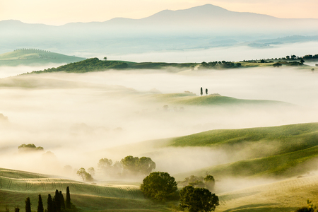 The fairytale foggy landscape of Tuscan fields at sunrise, Italy, Europeの写真素材