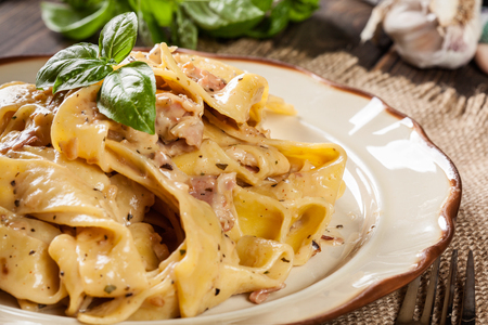 Pappardelle pasta with prosciutto and cheese sauce on a plate. Food and drinkの写真素材