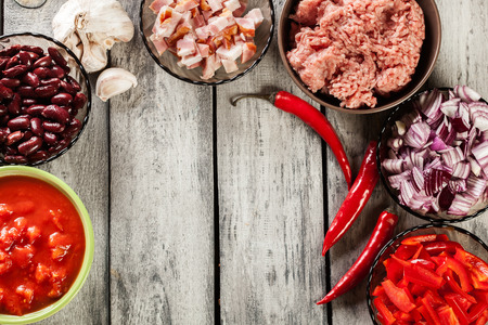 Ingredients ready for preparing chili con carne. Mincemeat, paprika, tomatoes, red beans, onion and bacon. Top viewの写真素材