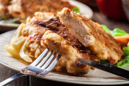 Close up of chicken medallions piece served with chips and salad.の写真素材
