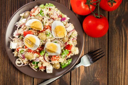 Fresh salad with couscous, eggs, paprika, red onion, feta cheese and olive. Eastern cuisine. Top viewの写真素材