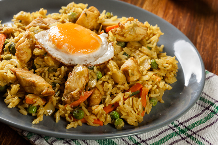 Fried rice nasi goreng with chicken egg and vegetables on a plate. Indonesian cuisine.の写真素材