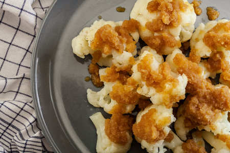 Vegetarian cooked cauliflower with bread crumbs and butter on a plate. Top viewの写真素材