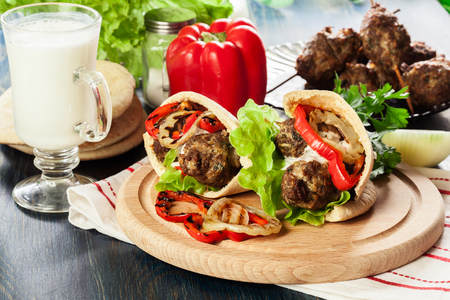 Tasty kofta kebab with grilled paprika and onion served on pita flatbreadの写真素材