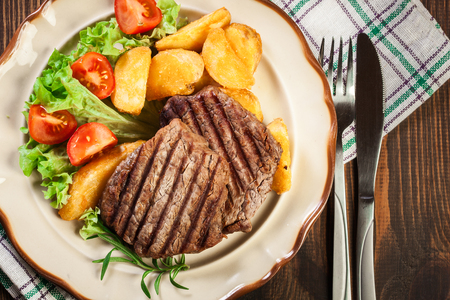 Succulent portions of grilled fillet mignon served with baked potatoes on a plate. Top viewの写真素材