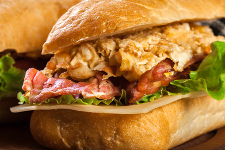 Ciabatta sandwich with smoked bacon and eggs on a cutting boardの写真素材