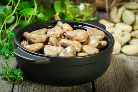 Broad beans stewed with onion and oregano on the wooden table. Sicilian cuisineの写真素材
