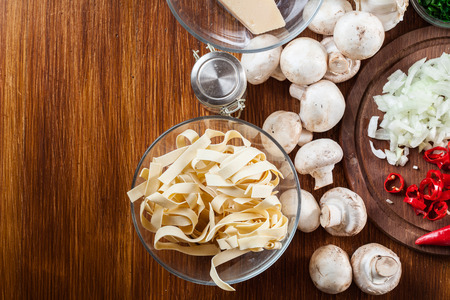Ingredients ready for prepare tagliatelle pasta with champignon in mushroom gravy. Top viewの写真素材