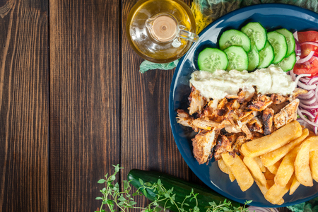 Greek gyros dish with french fries and vegetables. Served with tzatziki sauceの写真素材