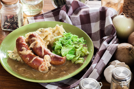 Bangers and Mash. Baked sausage in onion gravy served with mashed potatoes and cabbageの写真素材