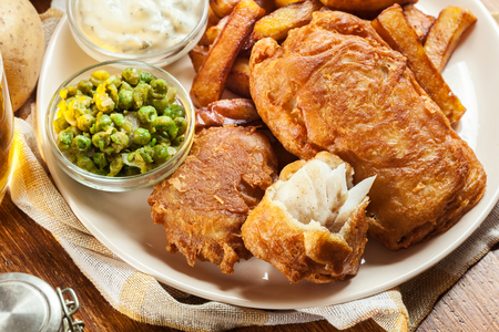 Traditional fish in beer batter and chips with green pea and tartar sauceの写真素材
